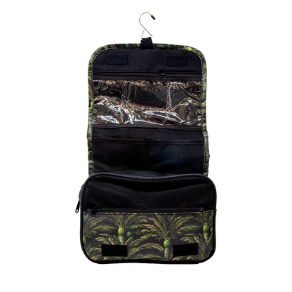A hanging toiletry bag with a green and black palm tree pattern, featuring a top hanger, clear plastic organizer pockets, and a zippered compartment, shown against a plain white background.