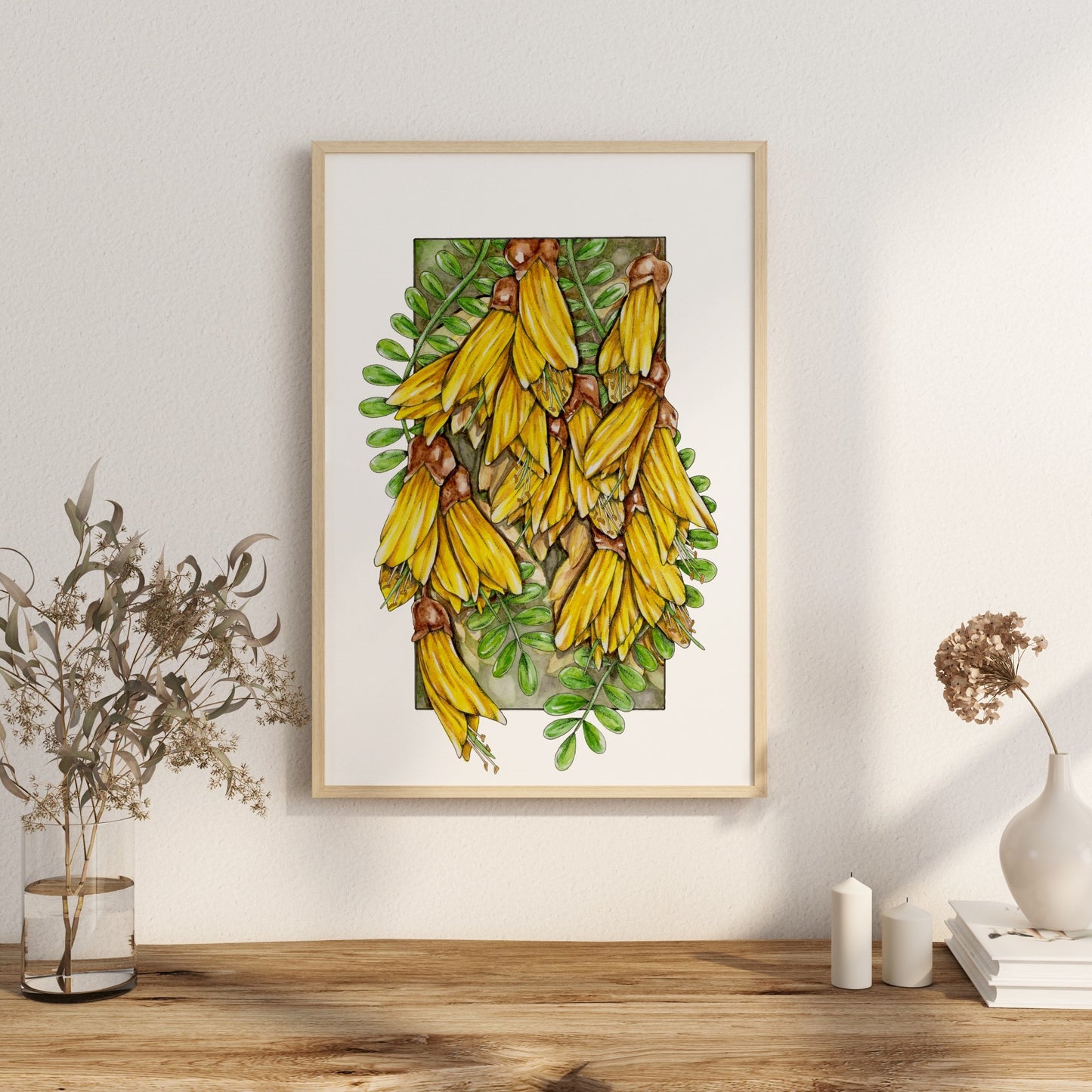 Artwork featuring yellow kowhai flowers cascading out of a frame amongst the green leaves.