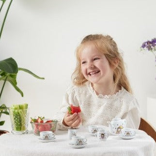 Child playing with a Childrens porcelain tea set featuring a princess and unicorn design.