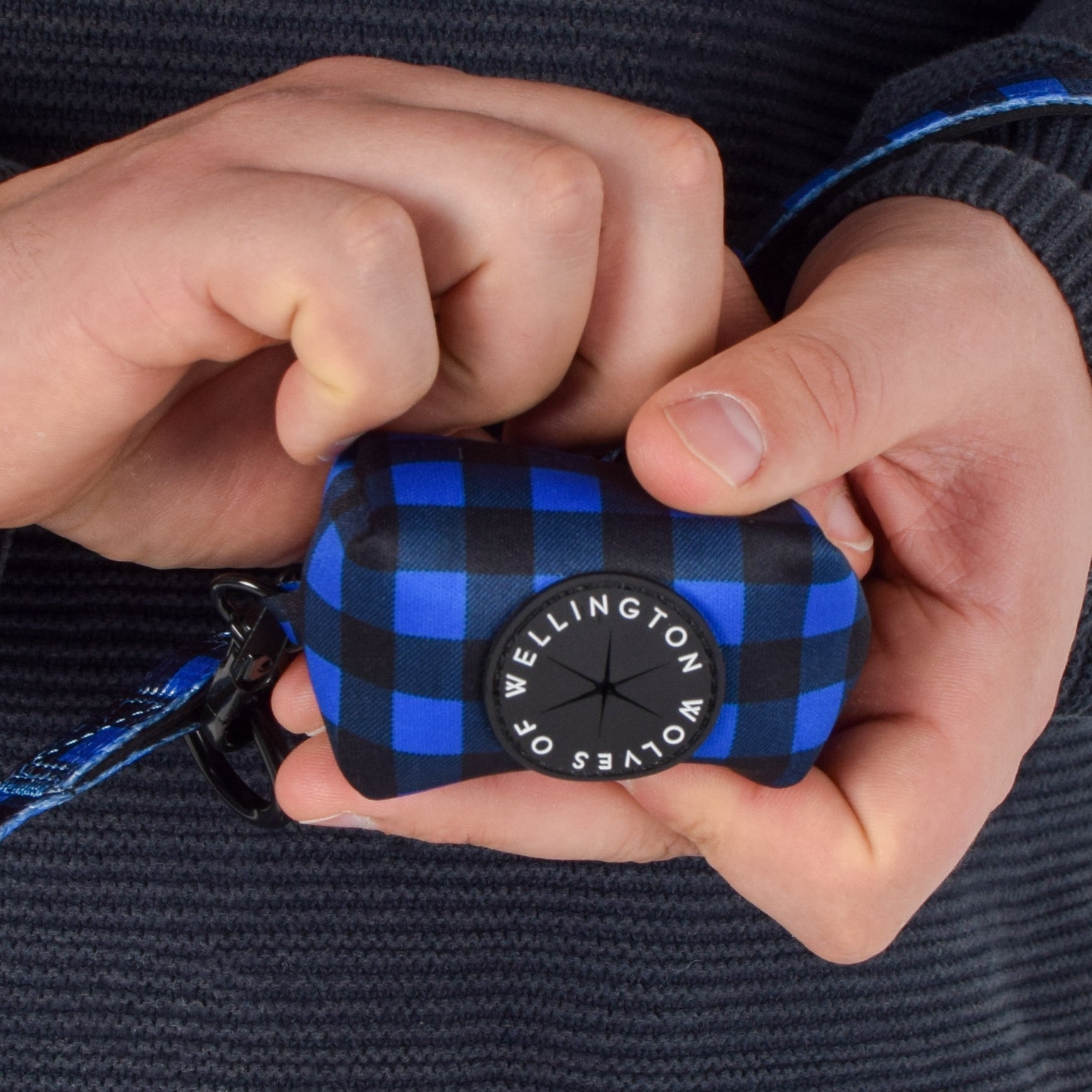Neoprene dog poop bag pouch in blue and black check pattern.