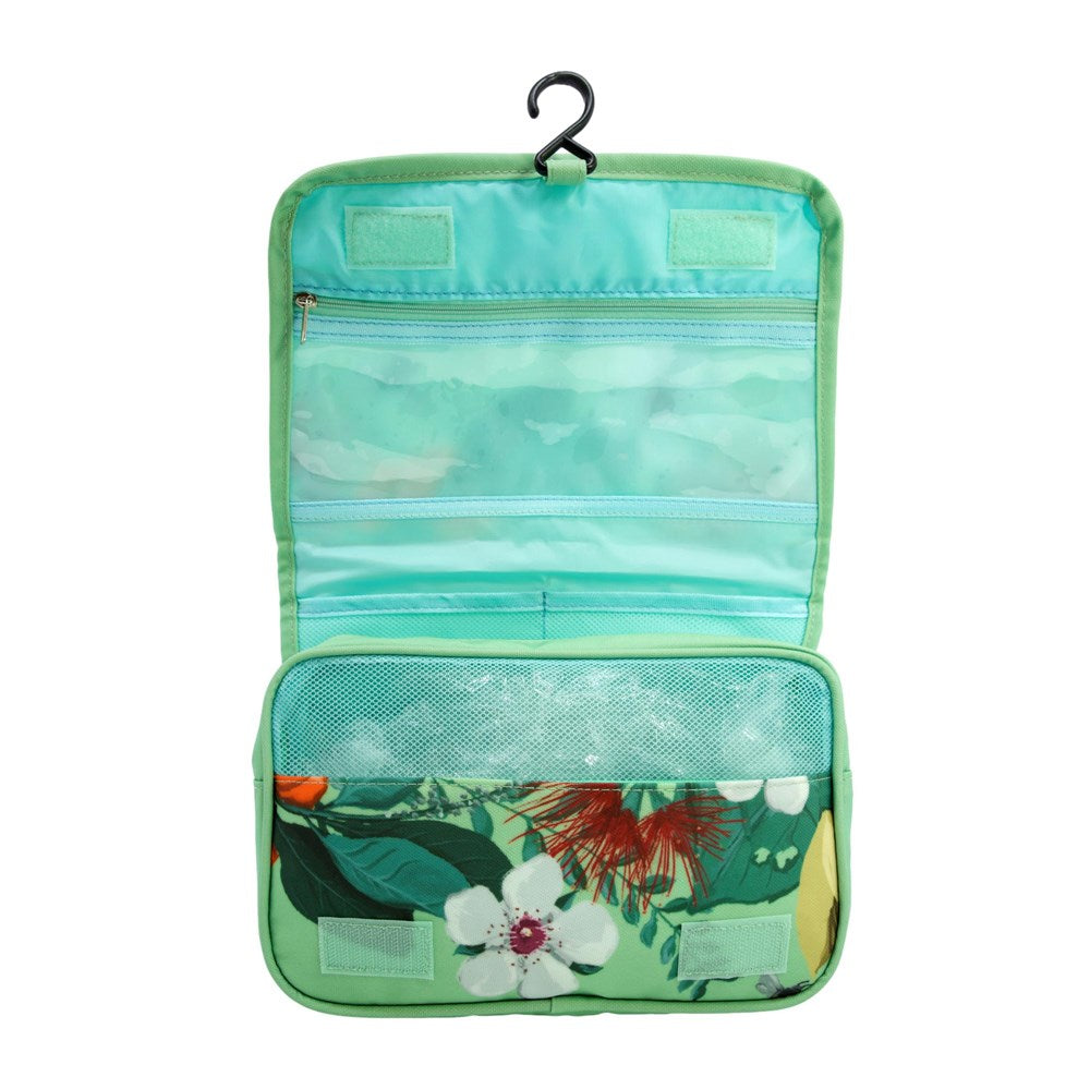 Inside of a hanging pale green toiletry bag with New Zealand floral pattern on the bottom pocket.