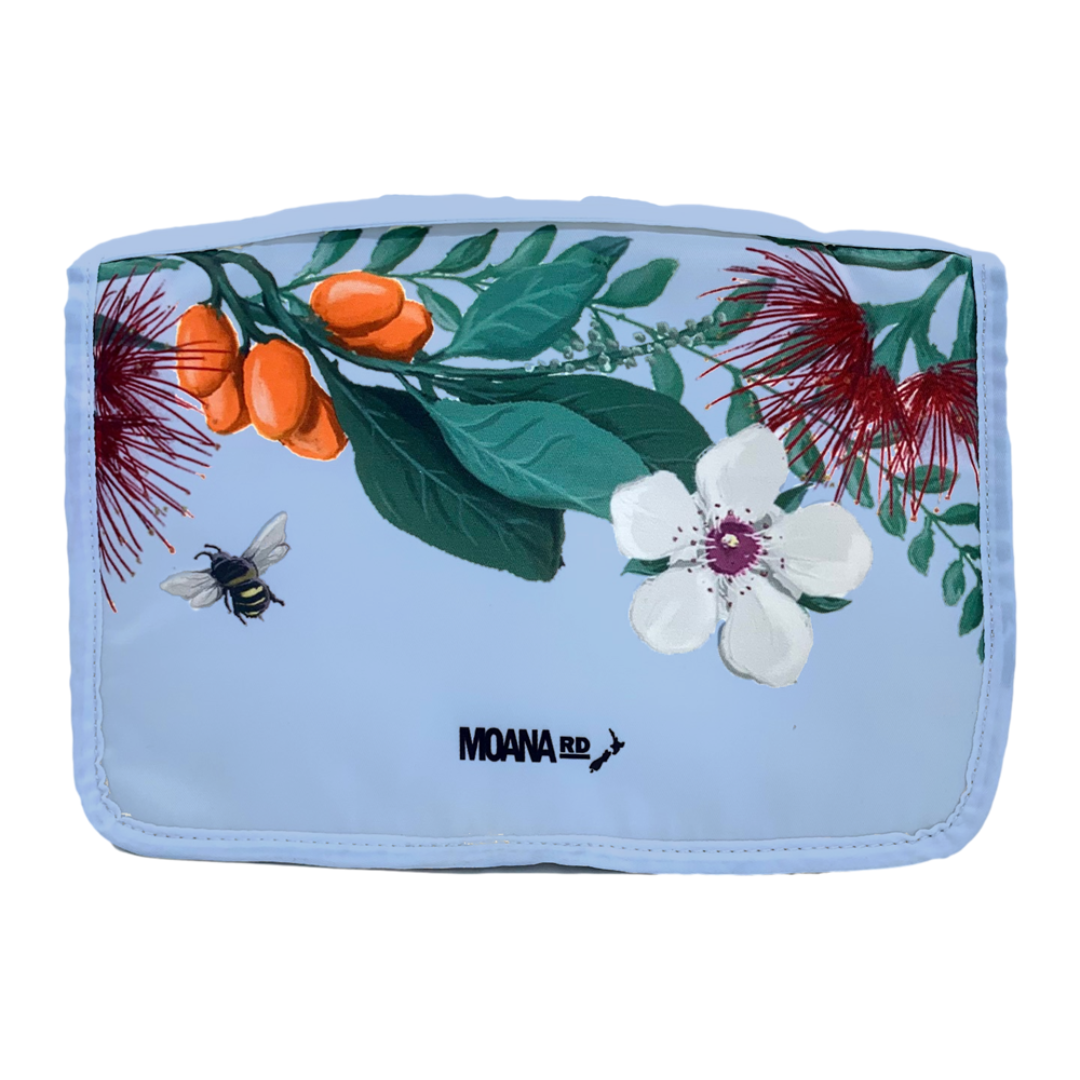 Pale blue toiletry bag with New Zealand floral pattern at the top.