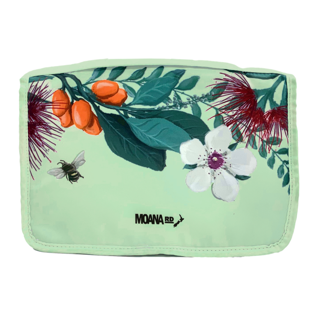 Pale green toiletry bag with New Zealand floral pattern at the top.