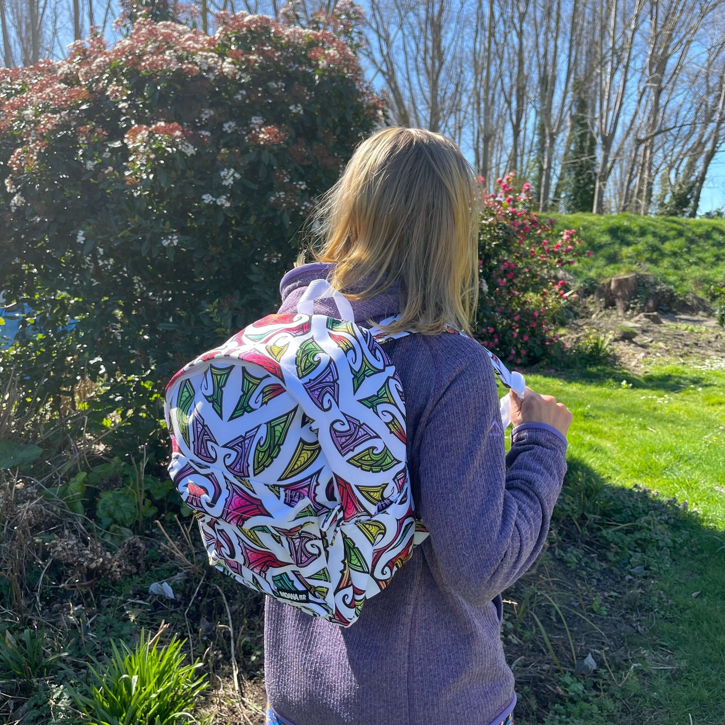 Kids backpack in white with colourful Maori design by Miriama Grace Smith.