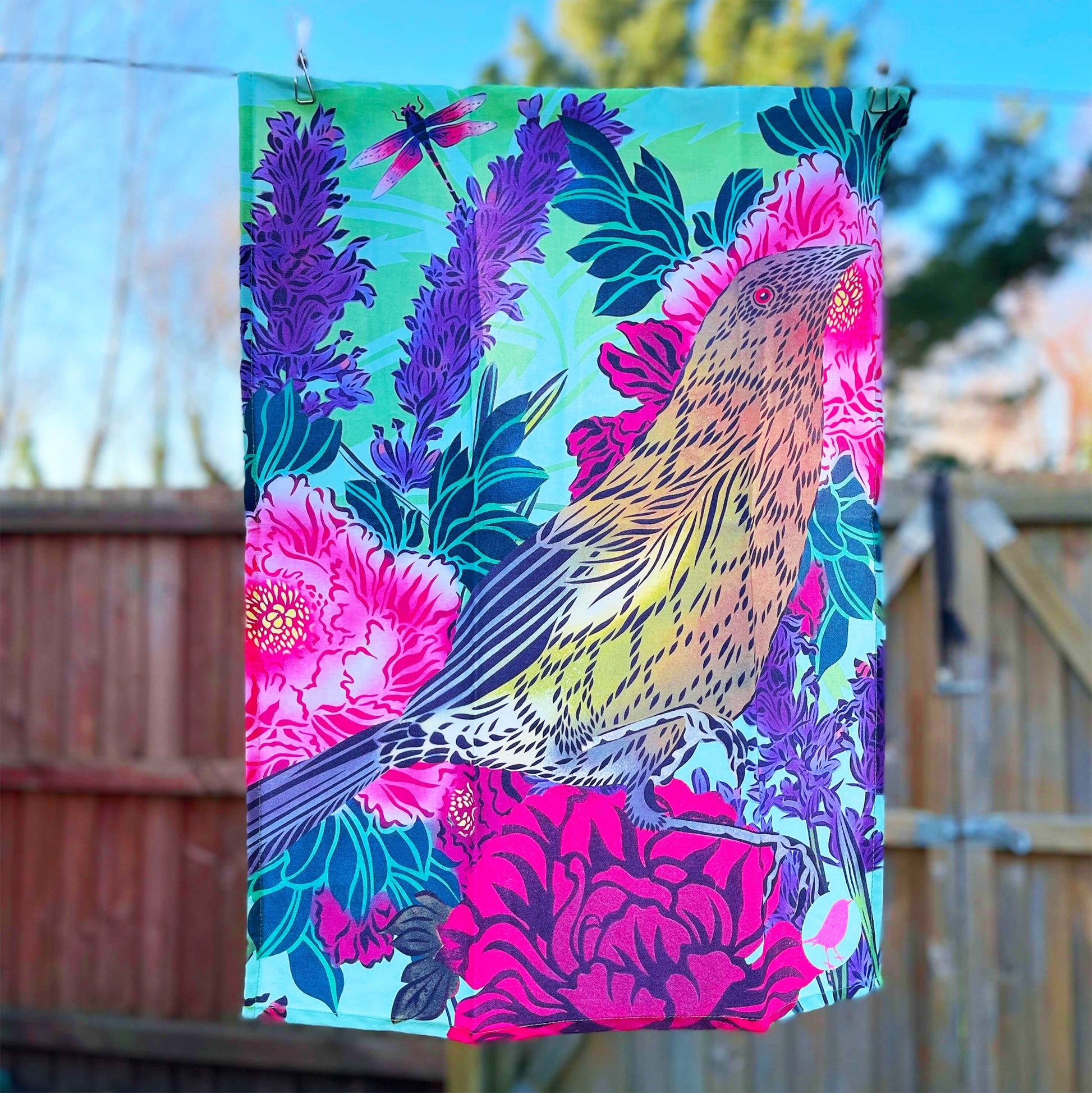 Beautiful tea towel by Flox design featuring a Koromiko and flowers hanging on a line.