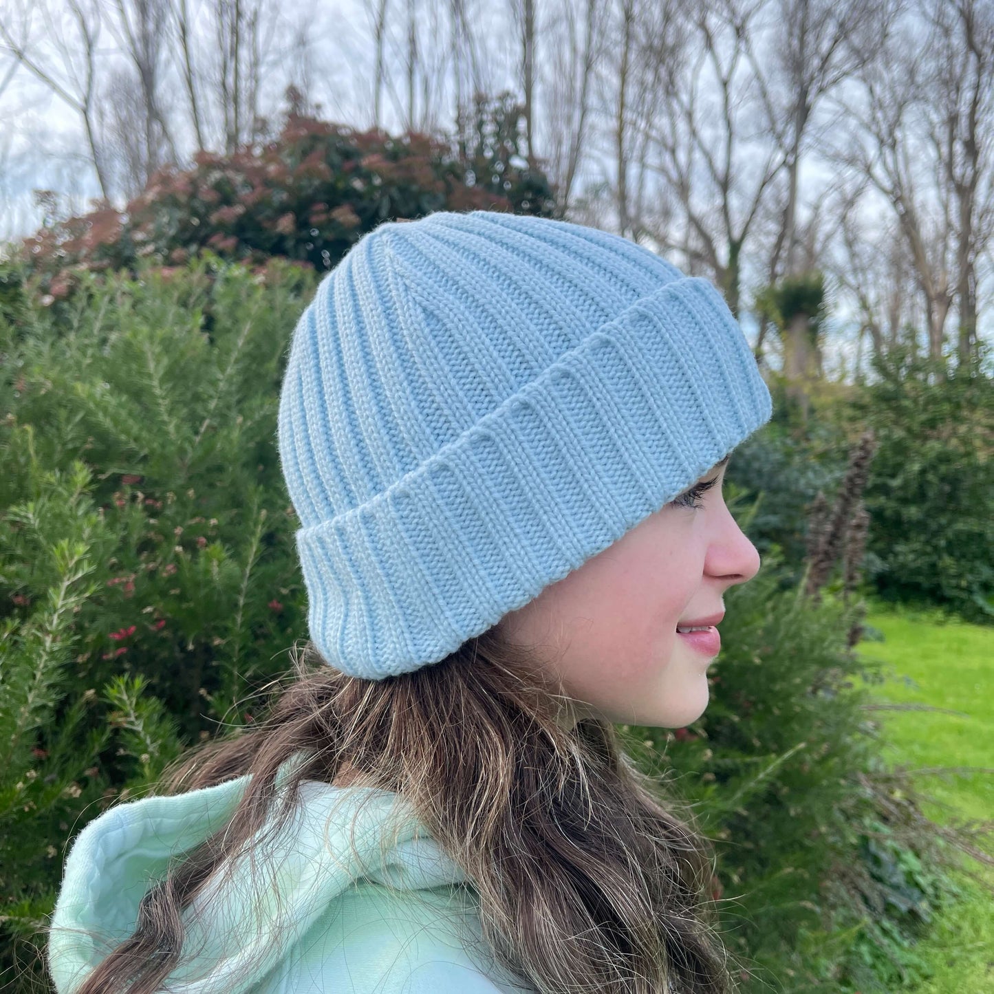Side view of child wearing light blue knit beanie.