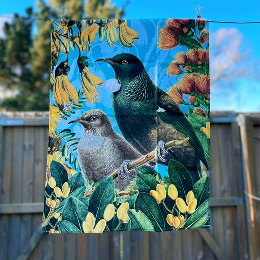 Tea towel with a Tui and flowers on it.