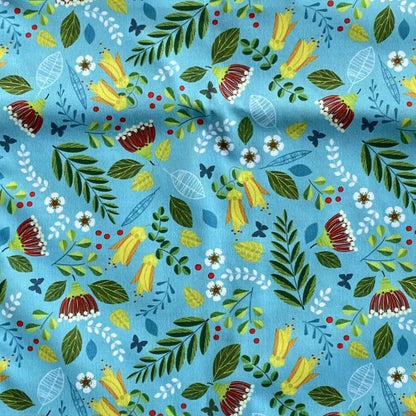 Close up of a blue fabric with native New Zealand flowers on it.