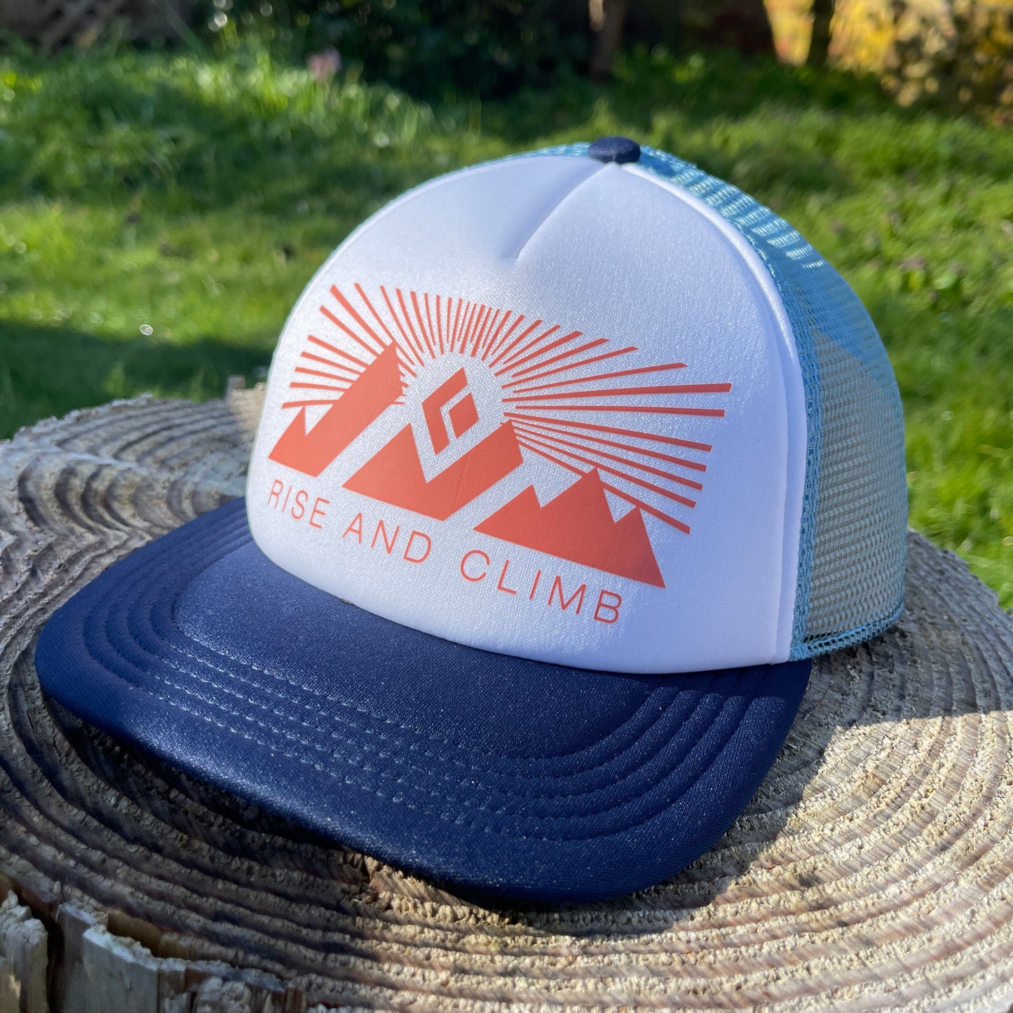 Blue brim trucker hat with white front and red Rise and Climb logo.