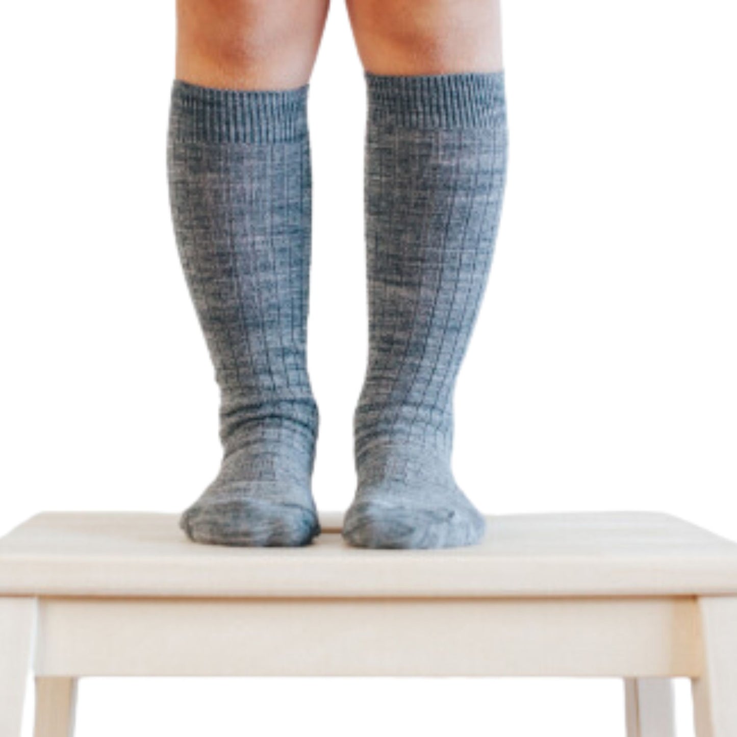 Child standing on stool wearing Knee high grey ribbed merino socks