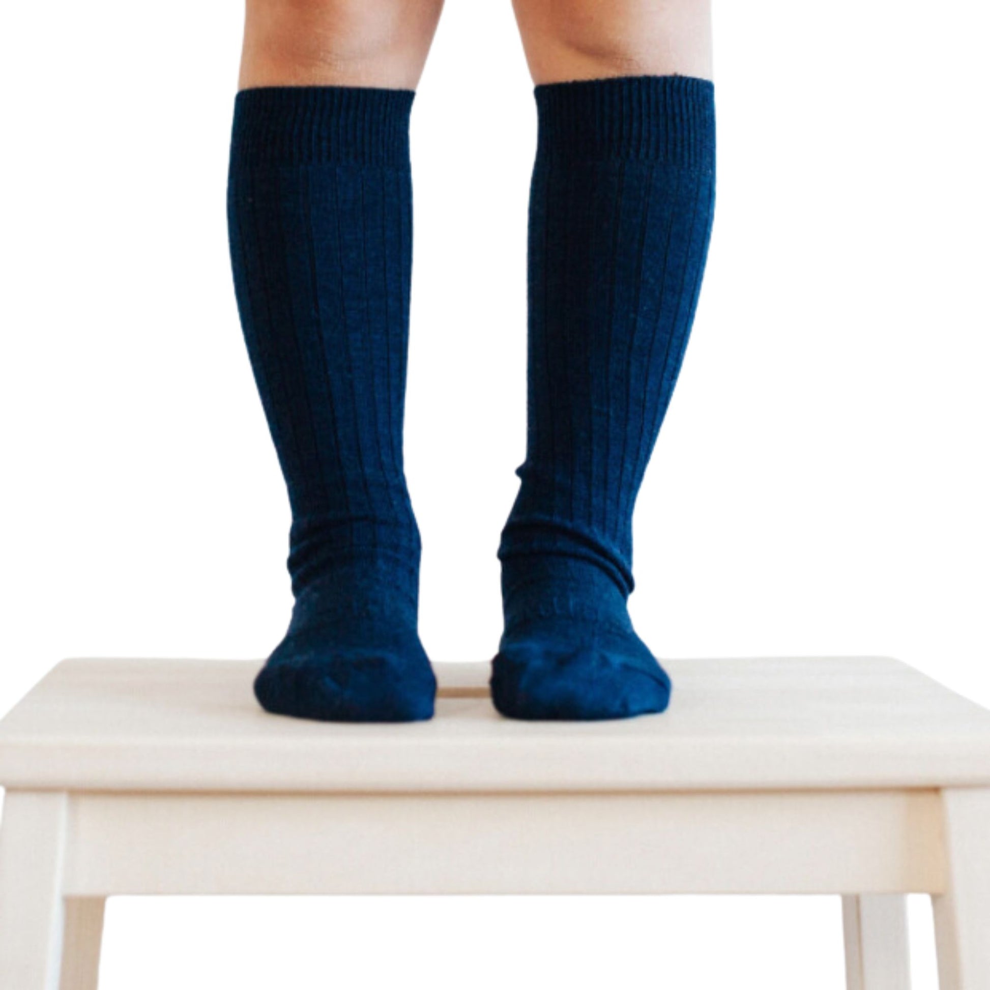 Child standing on stool wear knee high navy merino socks