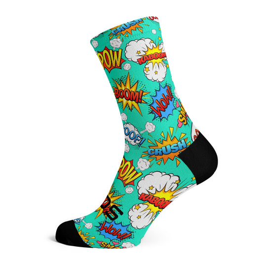 Multi coloured comic themed sock with bold font words saying BOOM! WOW! CRUSH! and KABOOM! on. The socks has a turquoise background with a black toe and heel areas. The words are highlighted in yellows, blues, reds and oranges