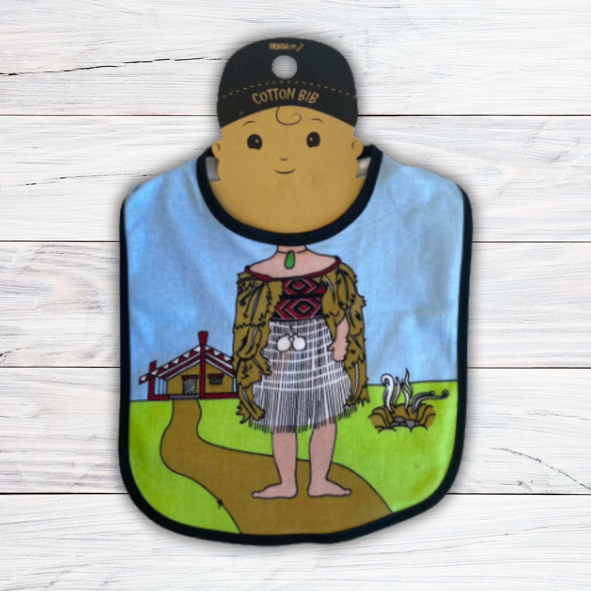 Baby bib with a maori wahine body and marae in the background.
