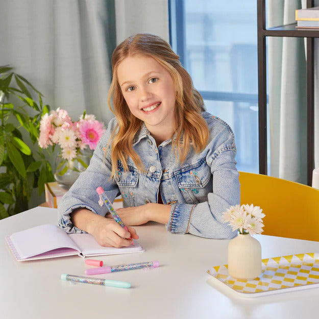 Young girl sitting at a desk writing in a notebook.