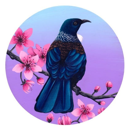 Art print by Anna Evans. The print is a large blue Tui bird sitting on a flowering manuka branch with pink flowers.