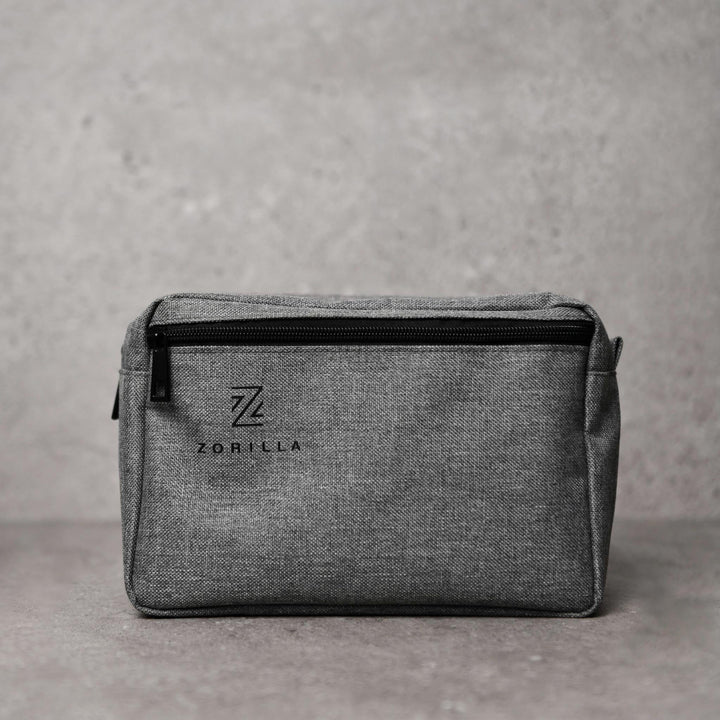 Grey mens toiletry bag with Zorilla logo printed on it.