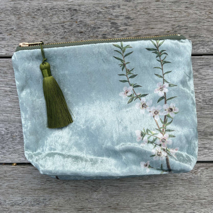 Icy blue velvet cosmetic bag with Manuka flowers and a green tassel.