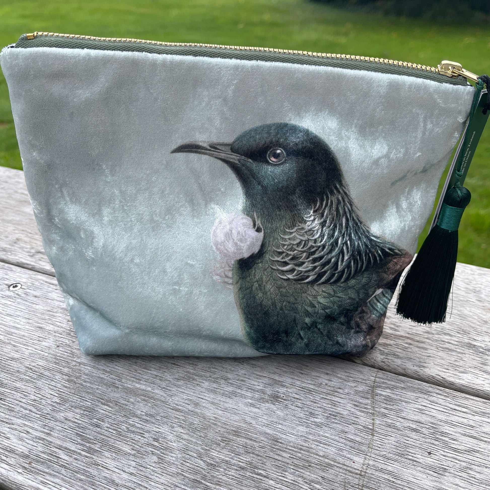 Velvet cosmetic bag featuring the head of a Tui bird.
