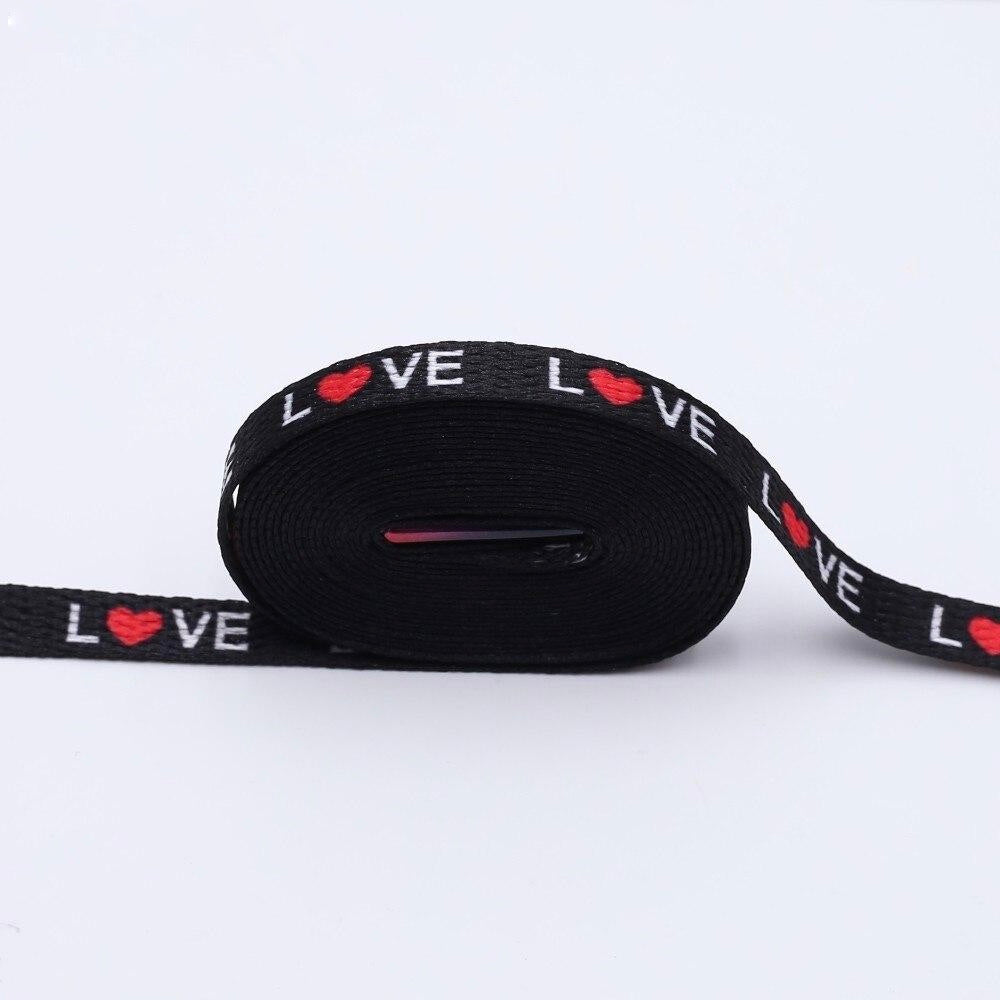 Black shoelaces with the word love printed on them and the O is a red heart.