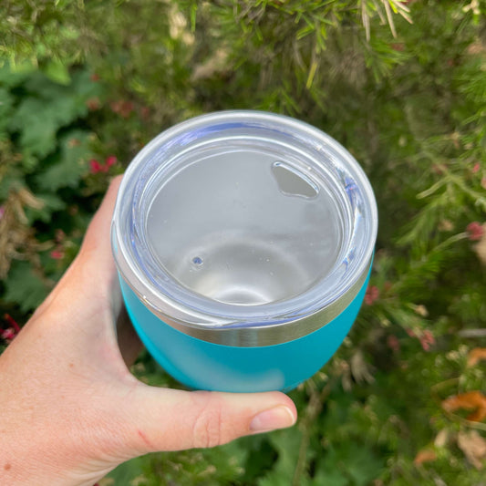 Birds eye view of a stainless coffee mug featuring the clear plastic sipper top.