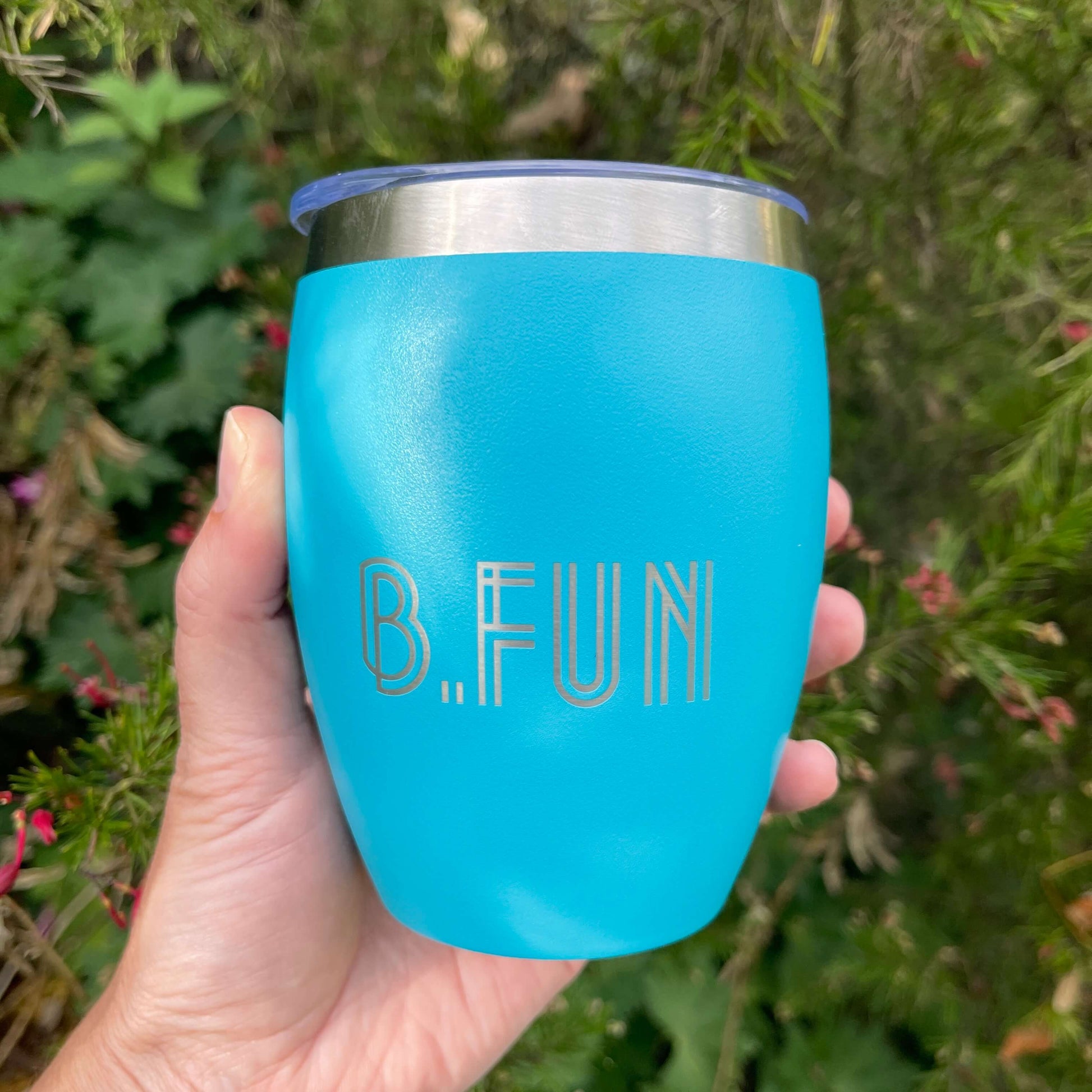 Turquoise stainless coffee mug with B.FUN engraved into it.