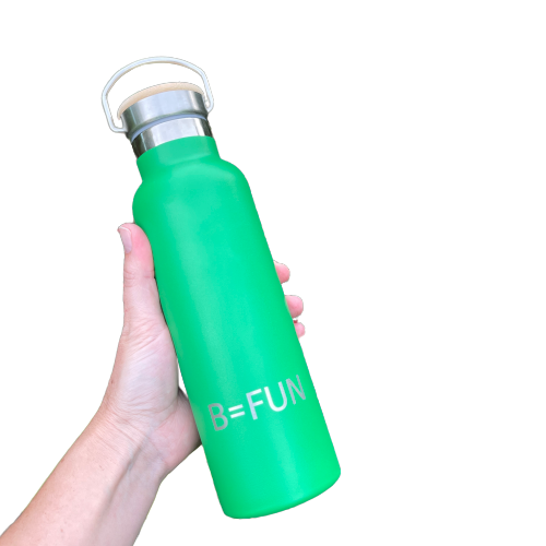 Womens hand holding a bright green stainless drink bottle with a bamboo cap and the words B=FUN engraved on it.