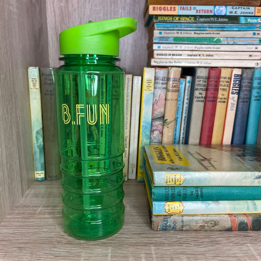 Bright green plastic sports water bottle with B=Fun printed on it sitting on a book shelf next to vintage books.