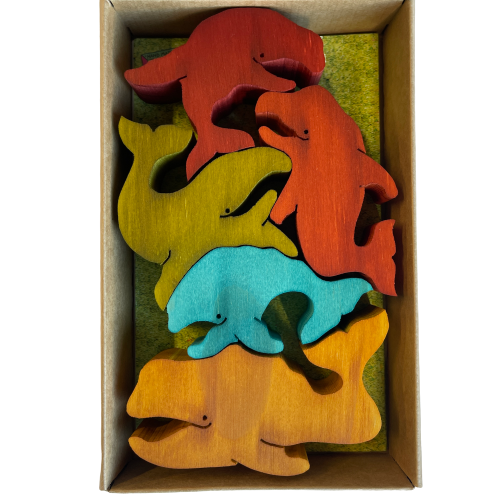 Box of coloured wooden balancing whales.
