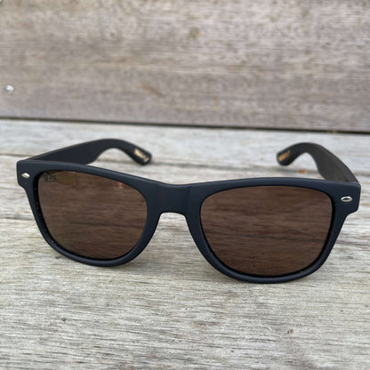 Sunglasses with dark wooden arms, black frames and dark lenses.