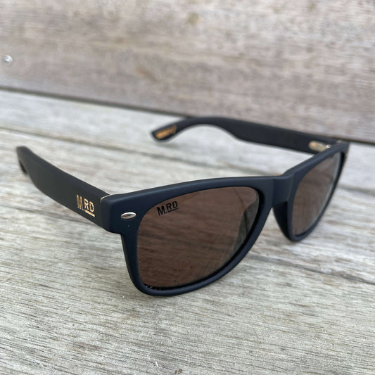 Sunglasses with dark wooden arms, black frames and dark lenses.