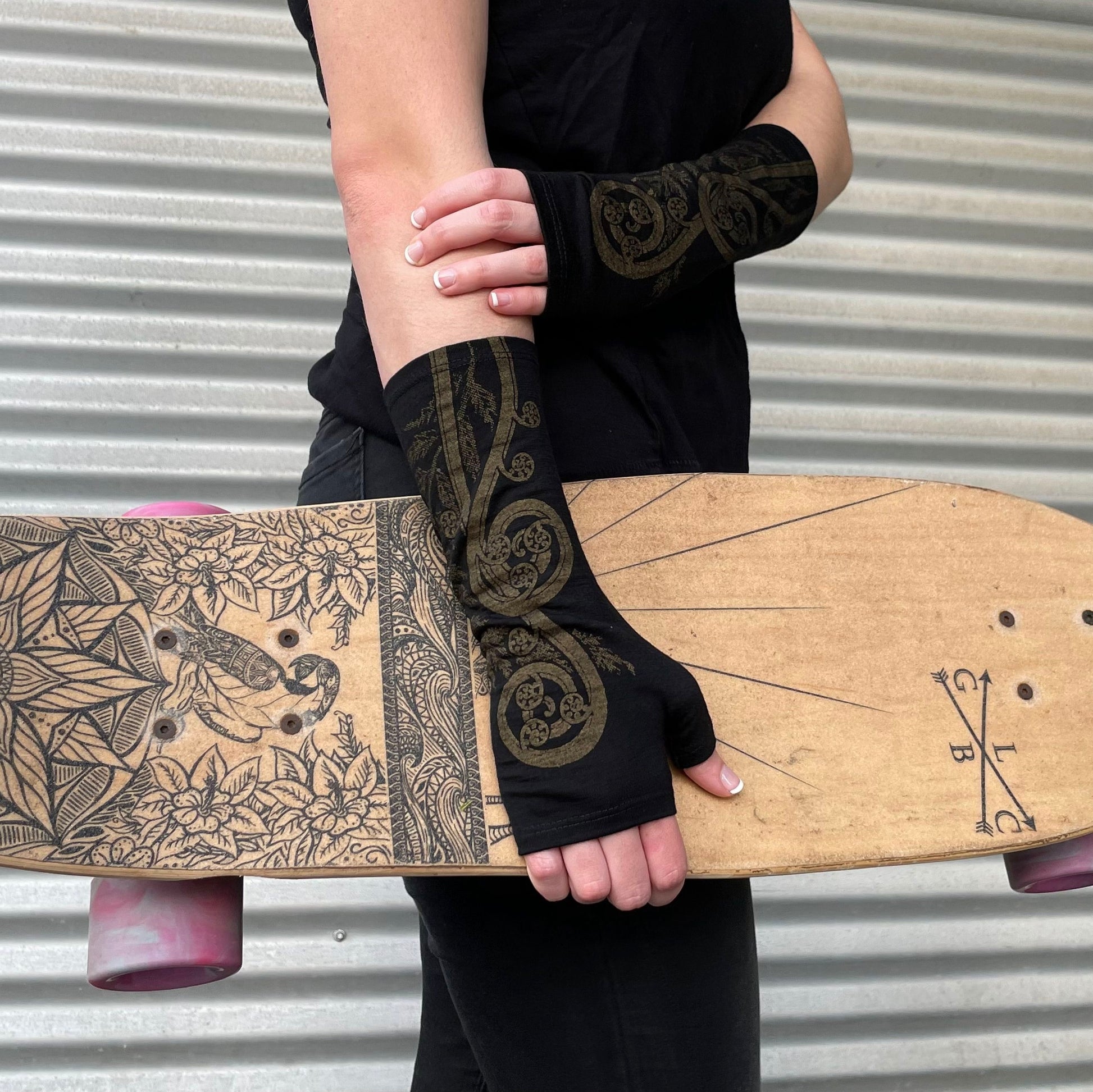 Fingerless merino gloves in black with gold fern print.