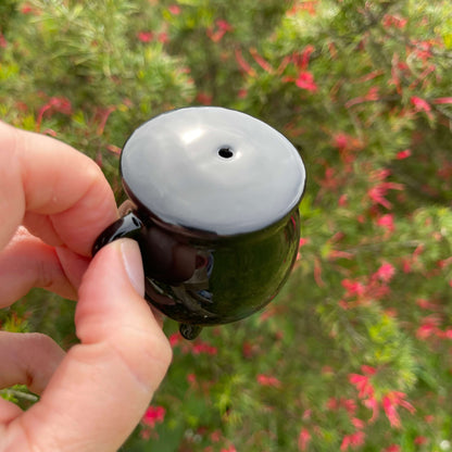 Black ceramic cauldron shaped salt shaker.