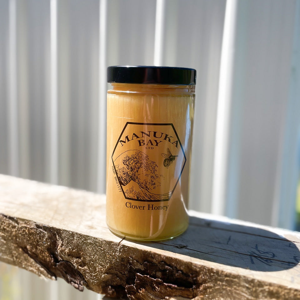 Glass jar with black lid filled with Manuka Bay Clover Honey.
