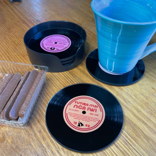 LP Record shaped coasters on a coffee table with a mug and chocolate biscuits.