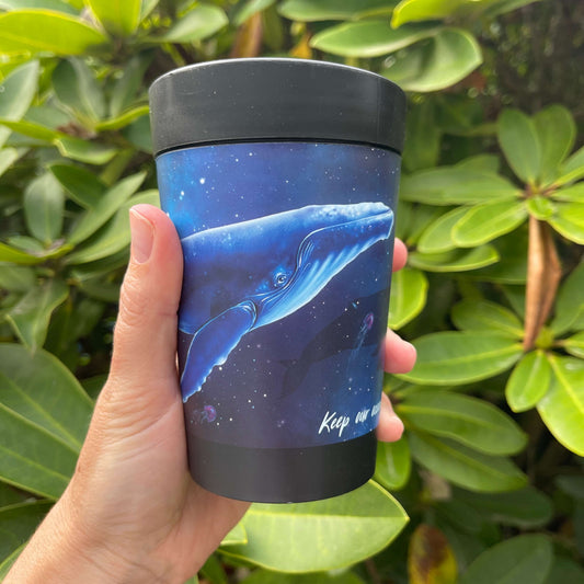 Black reusable coffee cup with blue galaxy wrap featuring a Humpback whale and the words "Keep our oceans beautiful".