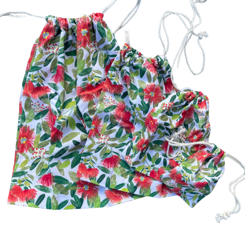 Four different sized drawstring bags in a Pohutukawa flower print.