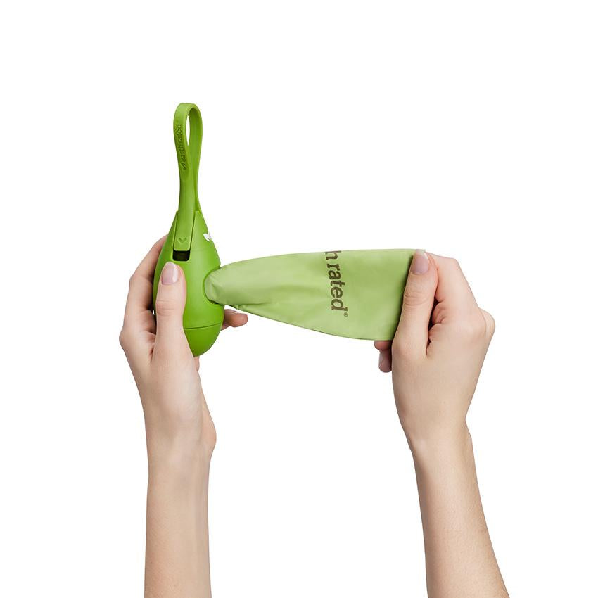 Bright green silicone tea drop shaped dog poo bag dispenser showing a women's hands removing a bag from the dispenser.