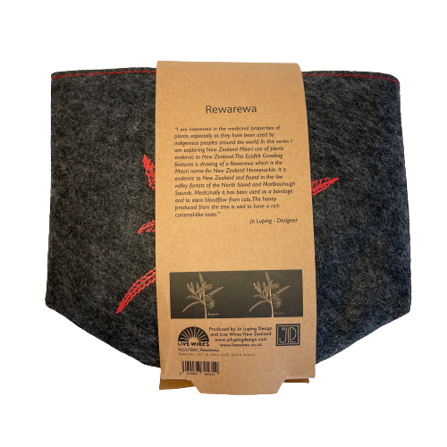 Dark grey felt planter with a rewarewa plant printed on it in red and sitting in a grey dish, flat packed and wrapped with kraft paper.