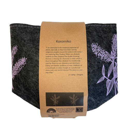 Dark grey felt planter with Koromiko flowers printed on it in purple, flat packed and wrapped with kraft paper.