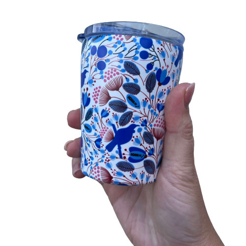 Small reusable coffee cup in white with a blue and red Tui bird and floral design.