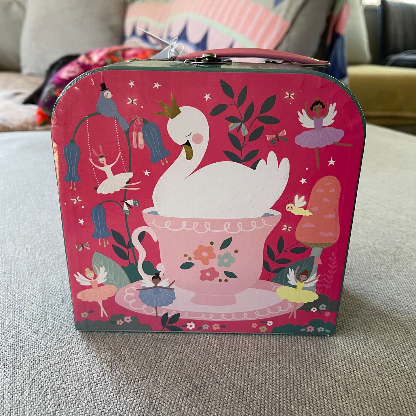 Bright pink childrens cardboard suitcase with fairys and swans.