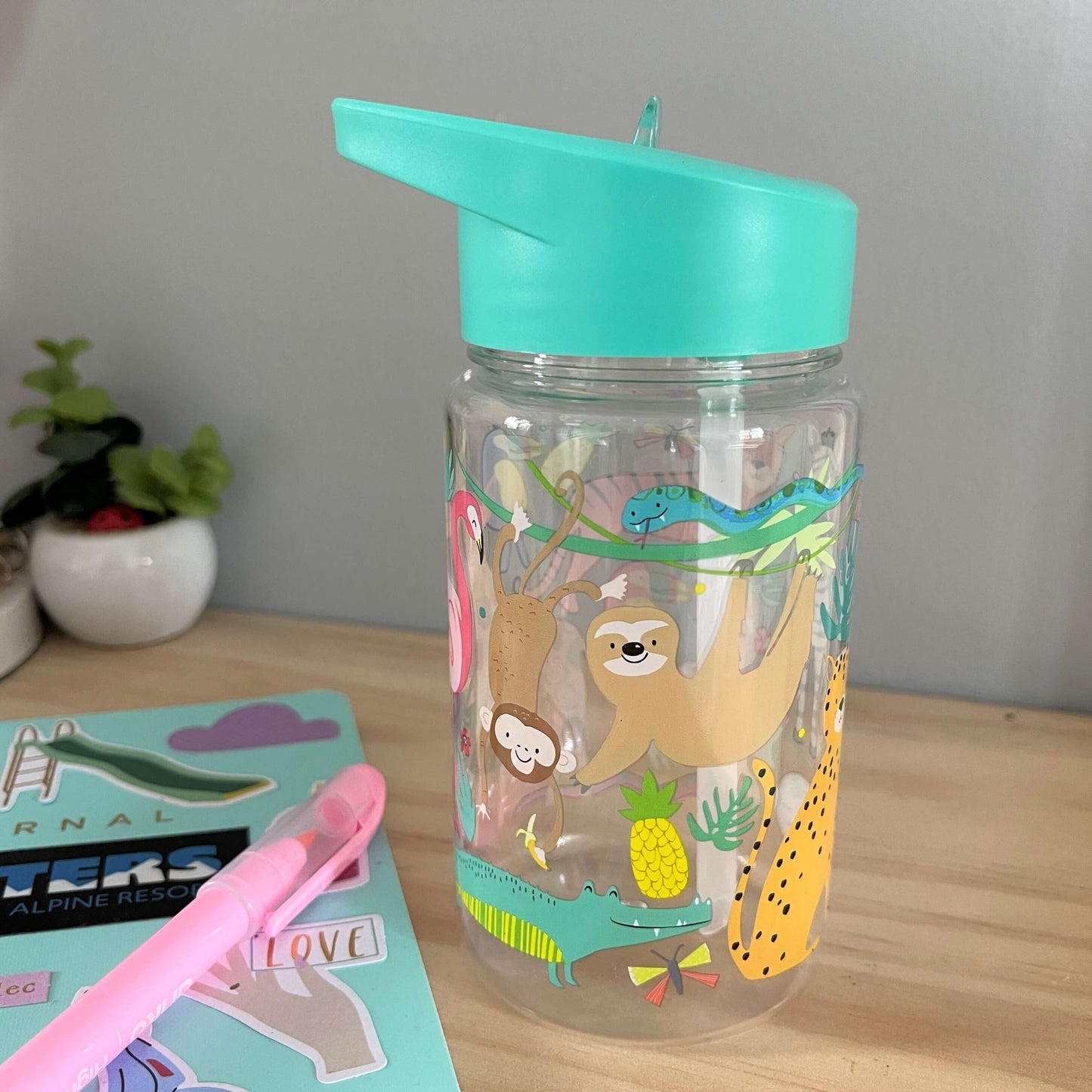 Kids drink bottle with jungle animals printed on it. Features aqua blue lid with clear sipping tube.