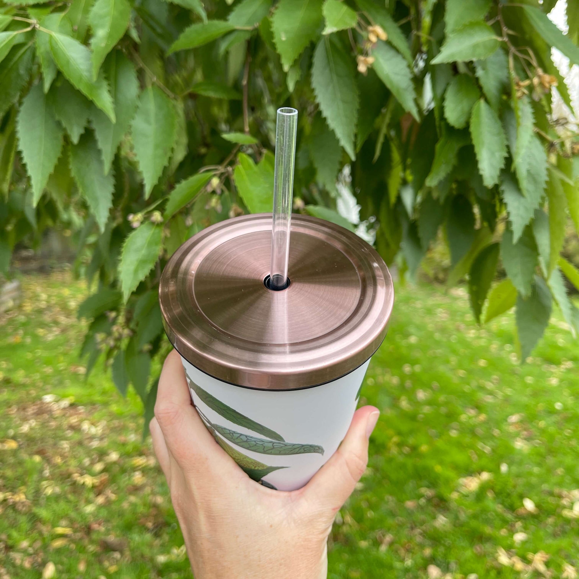 Rose Gold lid and clear straw of a reusable smoothie cup.
