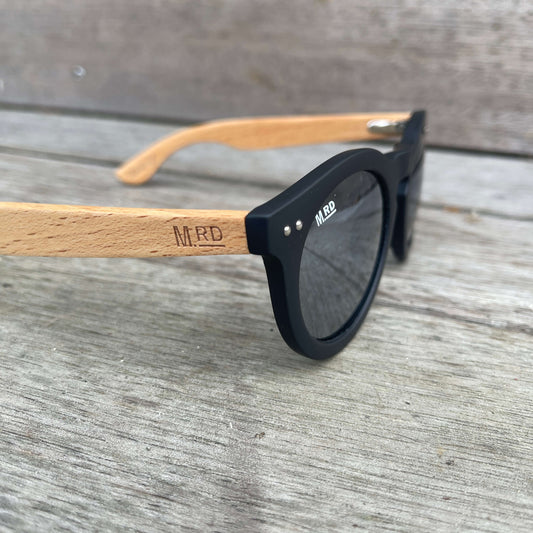 Womens sunglasses with black frames, wooden arms and silver reflective lenses in a Grace Kelly style.