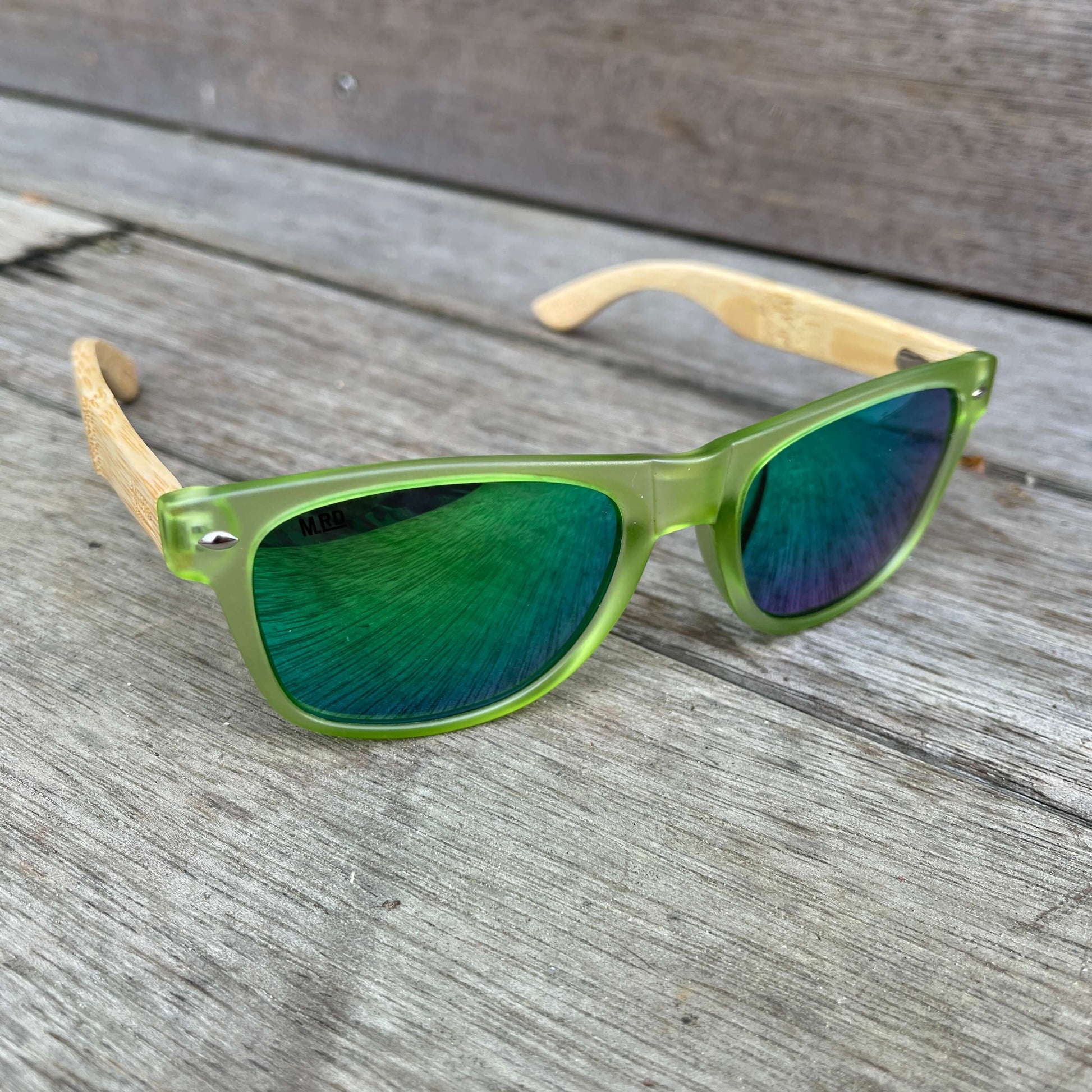 Sunglasses with wooden arms, green frames and reflective lenses.