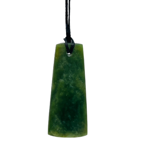 Greenstone freeform pendant on a black wax cord draped over a rock.