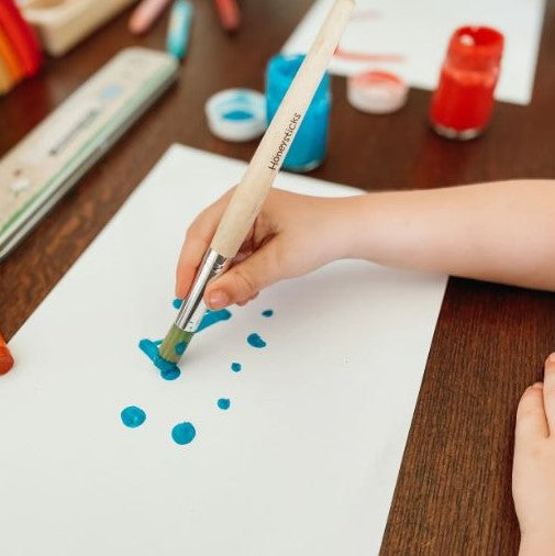 Child painting using a kids paint brush.