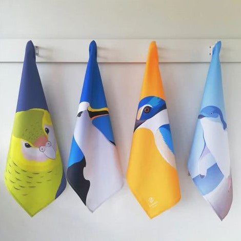 Assorted bird tea towels hanging on hooks.