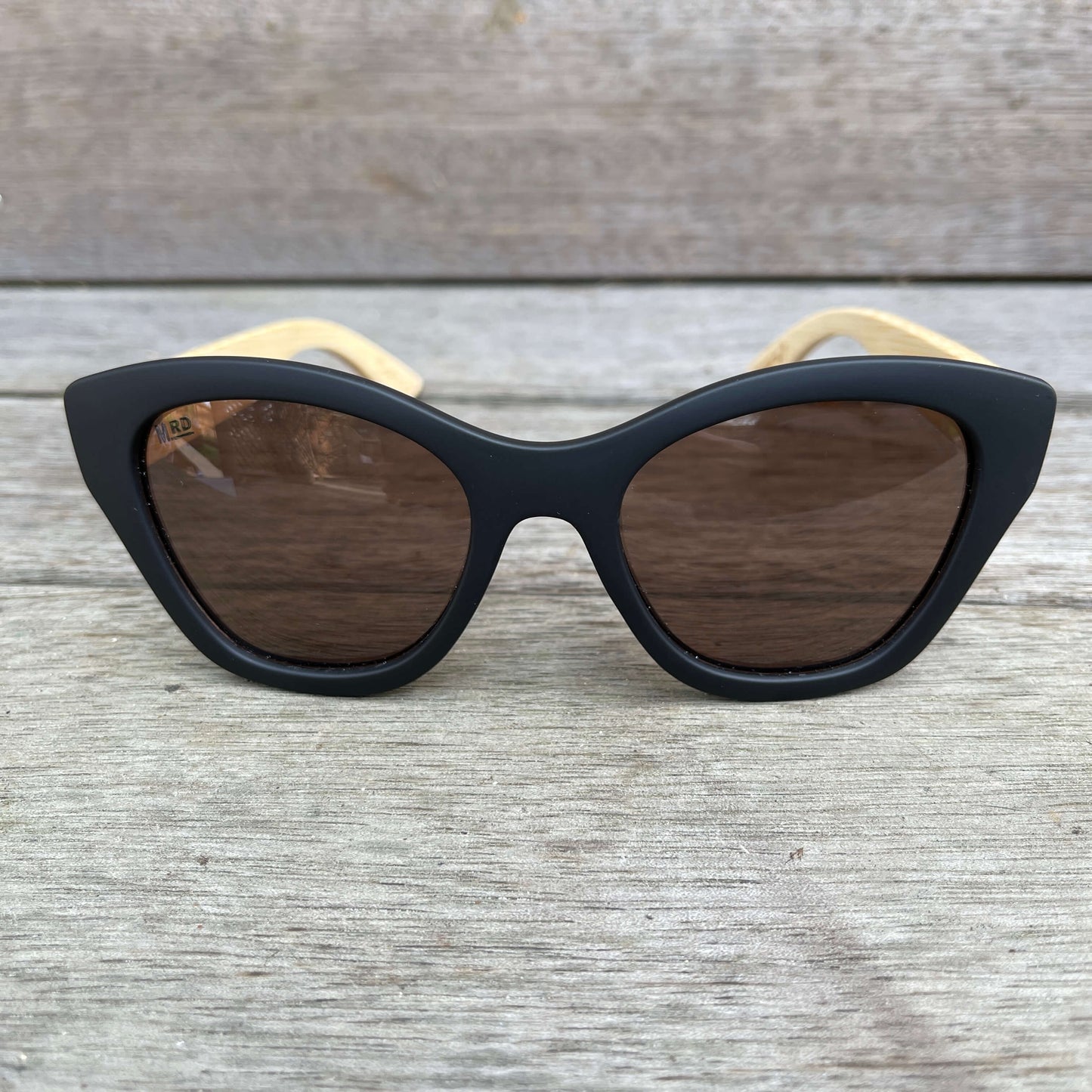 Womens sunglasses with black frames and wooden arms, in an Audrey Hepburn style.
