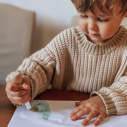 Toddler painting using a ergonomic toddler paint brush.